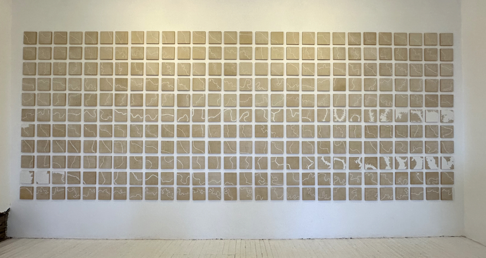 308 carved birch panels with plaster inlay, installed on large wall.